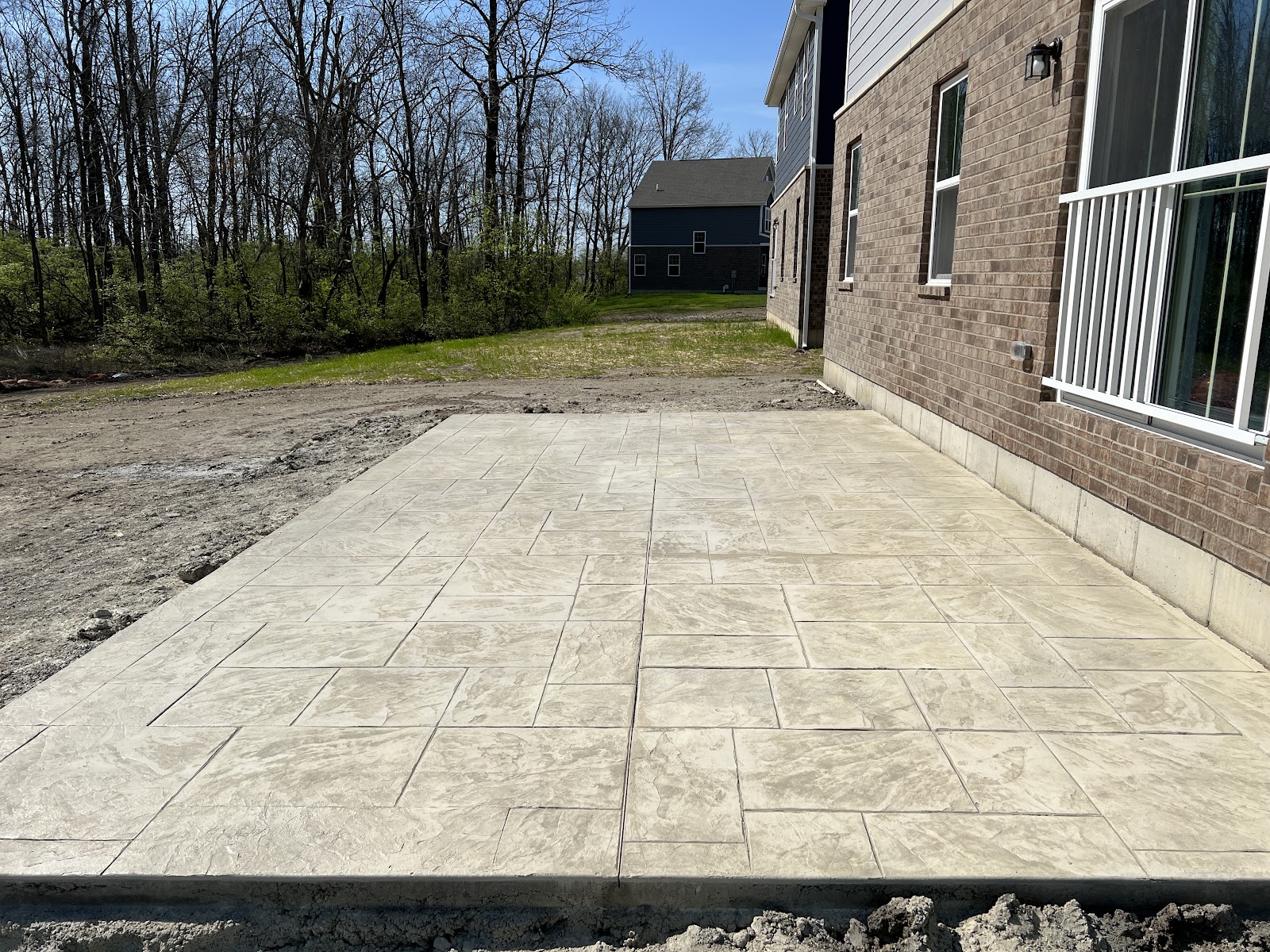 Cream-toned stamped concrete patio with a running-bond pattern at a new-construction home