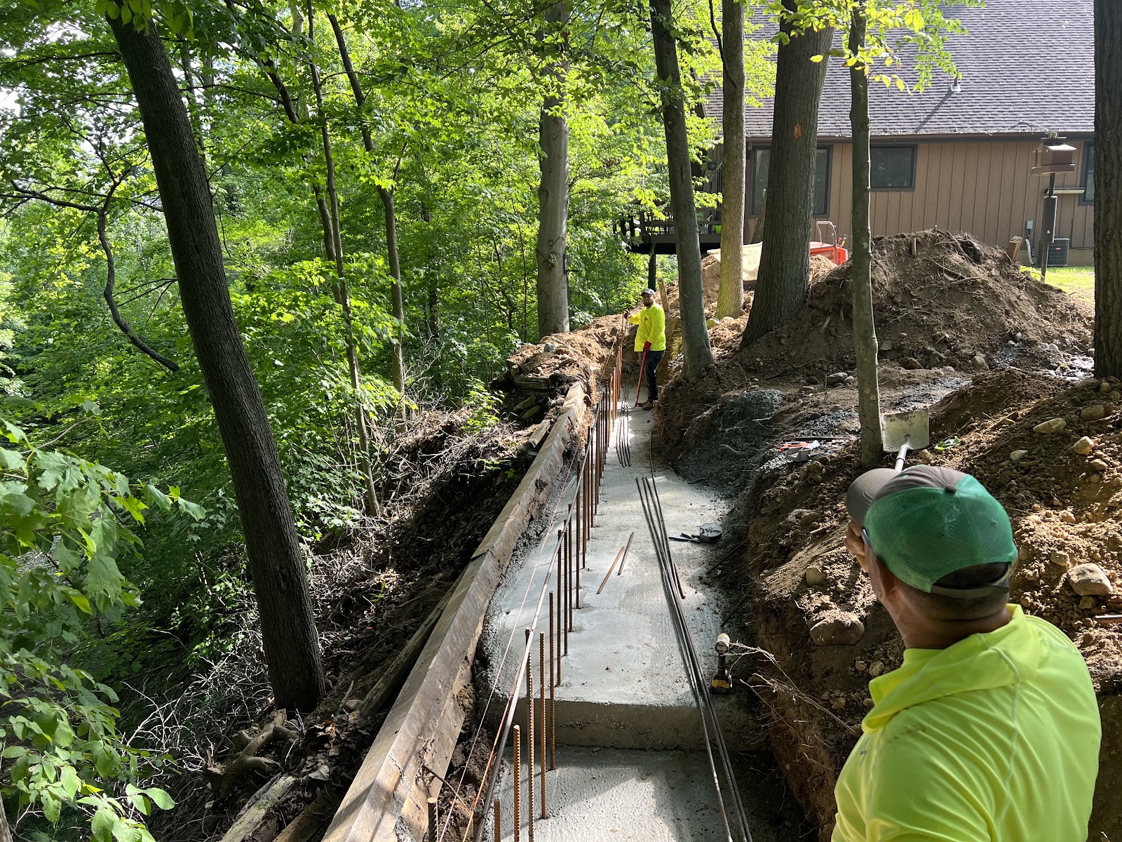 Grade Point Solutions crew forming and setting rebar for a hillside retaining wall footing