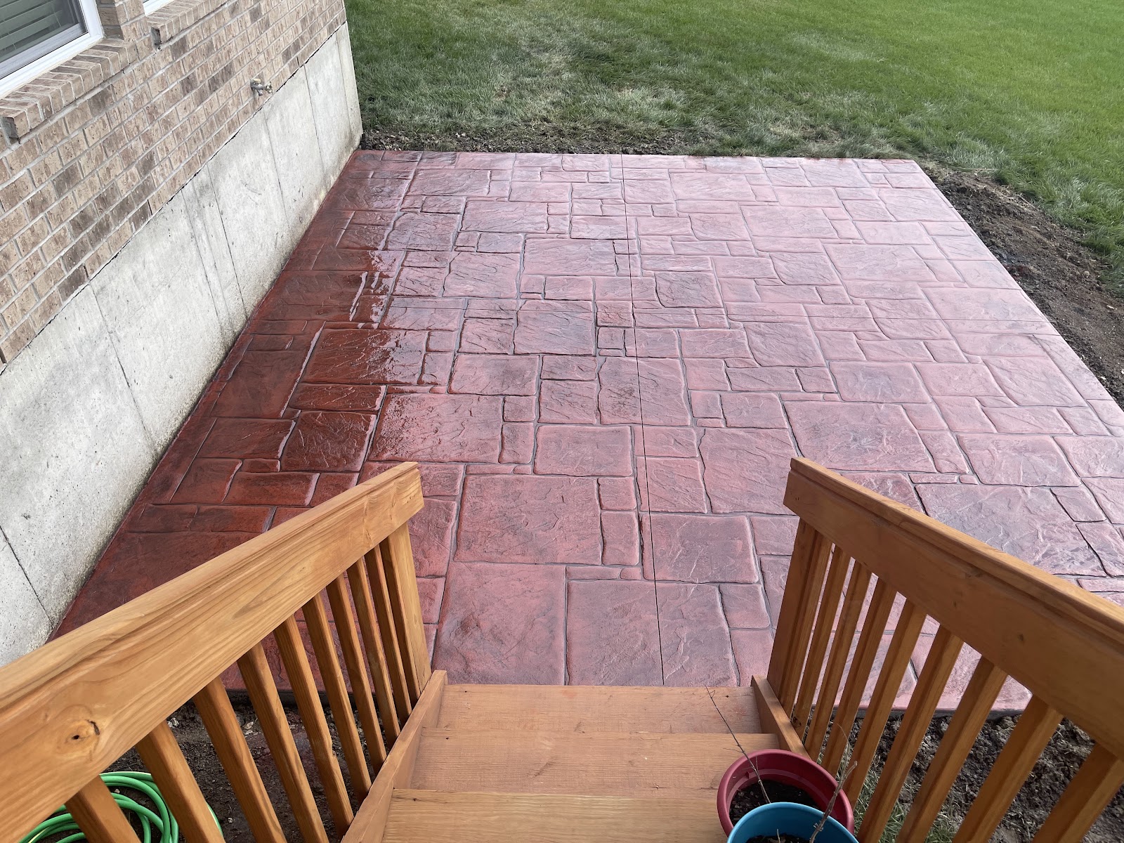 Brick-red stamped concrete patio with an ashlar slate pattern off a walkout basement